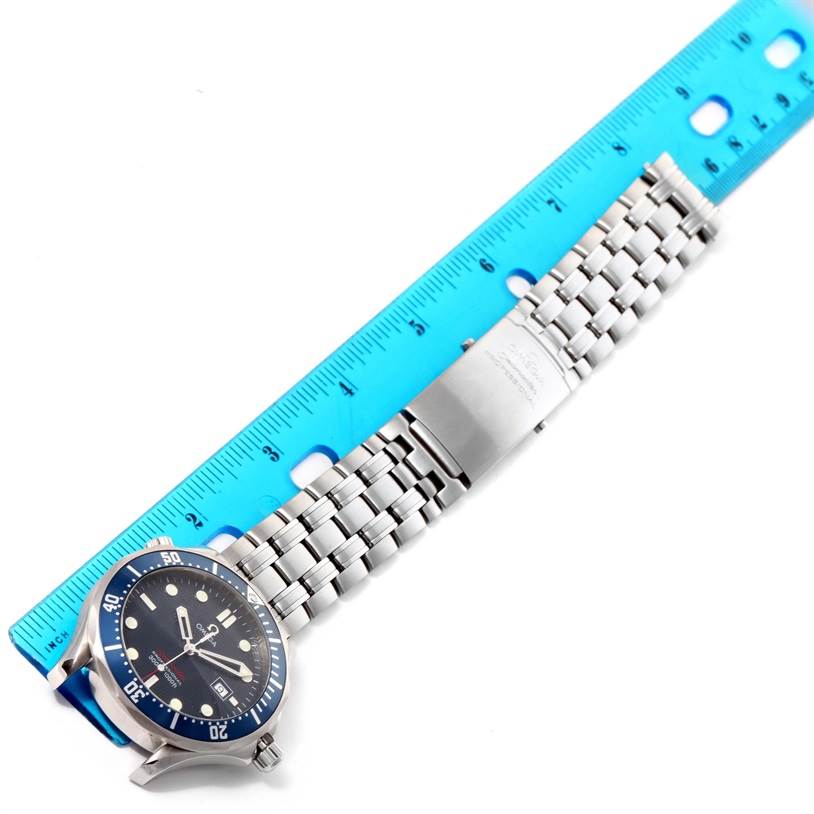 The Omega Seamaster 2221.80.00 Men
s Stainless Steel Blue Dial 2221.80.00 Men
s Stainless Steel Blue Dial watch is shown from a top-down angle, displaying the face, bracelet, and clasp next to a blue ruler for scale.