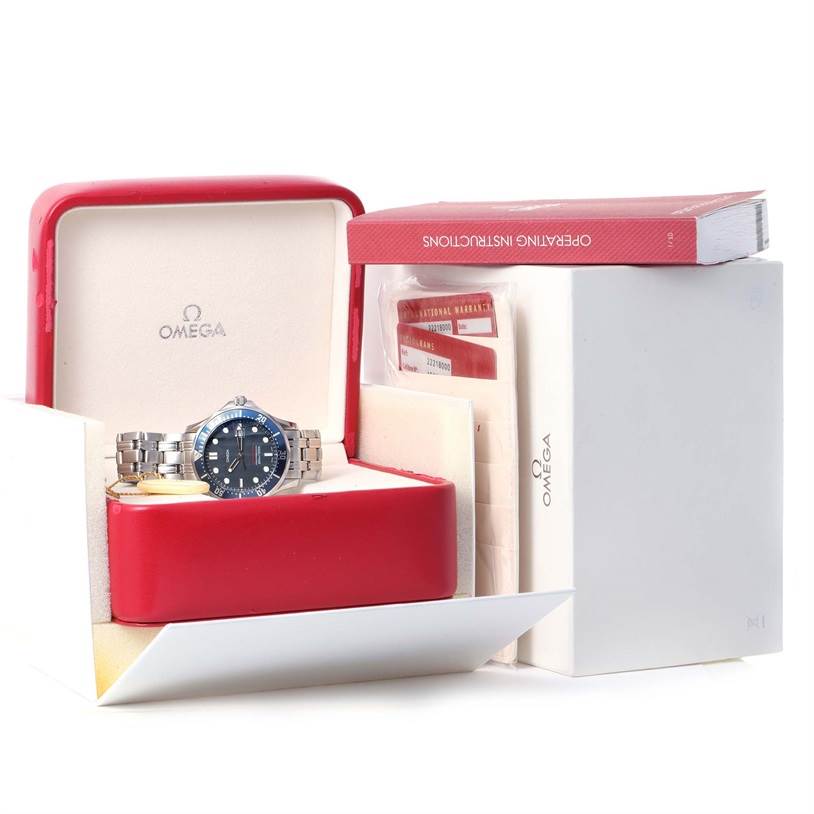 The image shows an Omega Seamaster 2221.80.00 Men
s Stainless Steel Blue Dial 2221.80.00 Men
s Stainless Steel Blue Dial watch in its red box, accompanied by an operating manual and warranty cards.