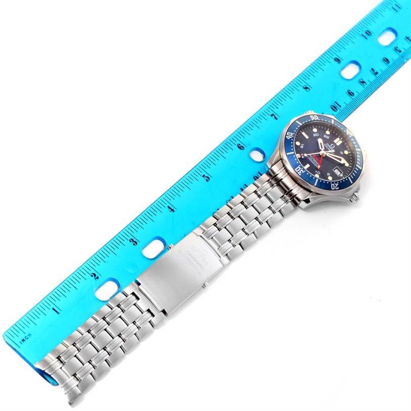 The image shows an Omega Seamaster 2535.80.00 Men
s Stainless Steel Blue Dial 2535.80.00 Men
s Stainless Steel Blue Dial watch with a stainless steel bracelet and a blue bezel, with a ruler measuring its length.