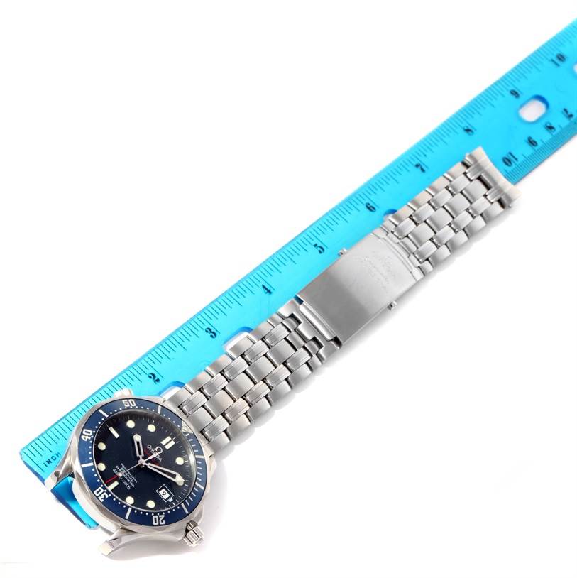 The image shows an Omega Seamaster 2220.80.00 Men
s Stainless Steel Blue Dial 2220.80.00 Men
s Stainless Steel Blue Dial watch laid flat next to a blue ruler, displaying the watch
s face, bracelet, and clasp.