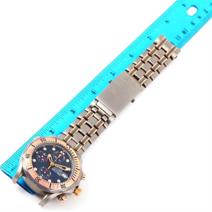 The Omega Seamaster 2296.80.00 Titanium Blue Dial 2296.80.00 Titanium Blue Dial watch is shown from a top view, displaying its face, bezel, and two-tone metal bracelet next to a ruler for scale.
