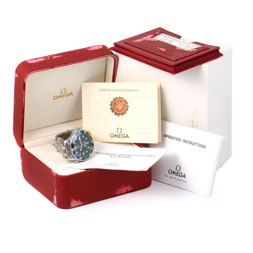 The image shows an Omega Seamaster 2531.80.00 Men
s Stainless Steel Blue Dial 2531.80.00 Men
s Stainless Steel Blue Dial watch displayed in an open red case with paperwork, including a warranty card and instruction manuals.