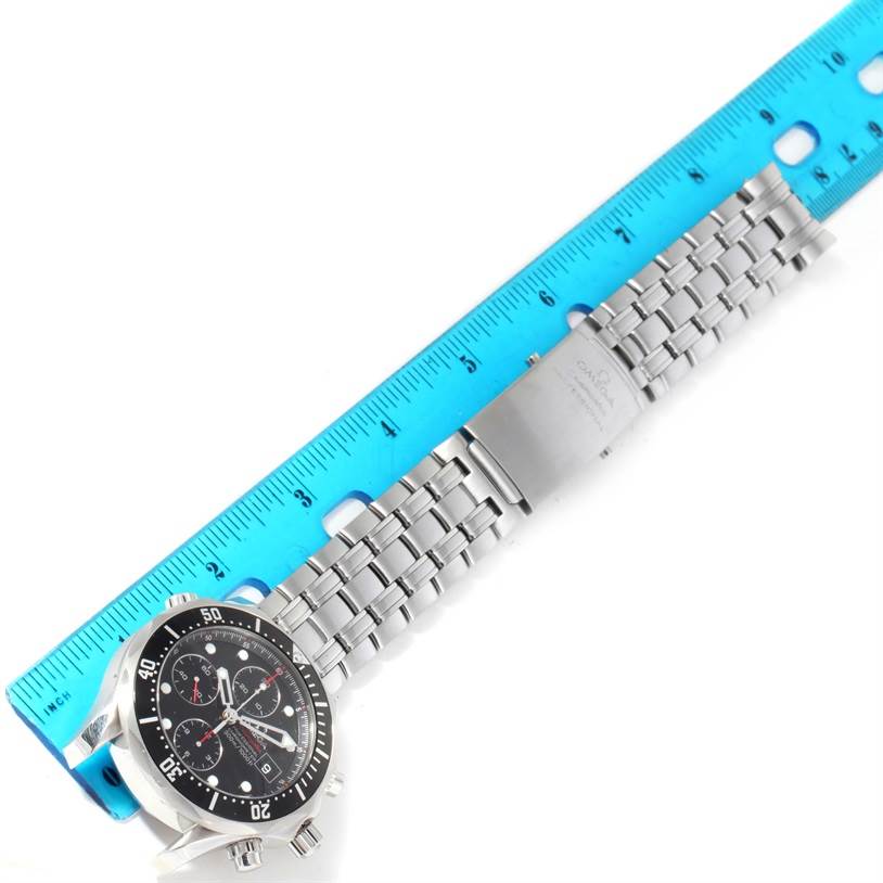 The Omega Seamaster 213.30.42.40.01.001 Men
s Stainless Steel Black Dial 213.30.42.40.01.001 Men
s Stainless Steel Black Dial watch is shown from a top view, highlighting its face and metal bracelet with a clasp, alongside a blue ruler for scale.