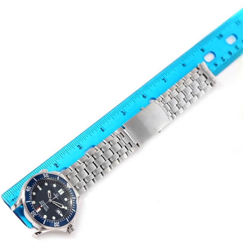 The image shows an Omega Seamaster 2541.80.00 Men
s Stainless Steel Blue Dial 2541.80.00 Men
s Stainless Steel Blue Dial watch from a top-down angle, along with its bracelet next to a blue ruler.