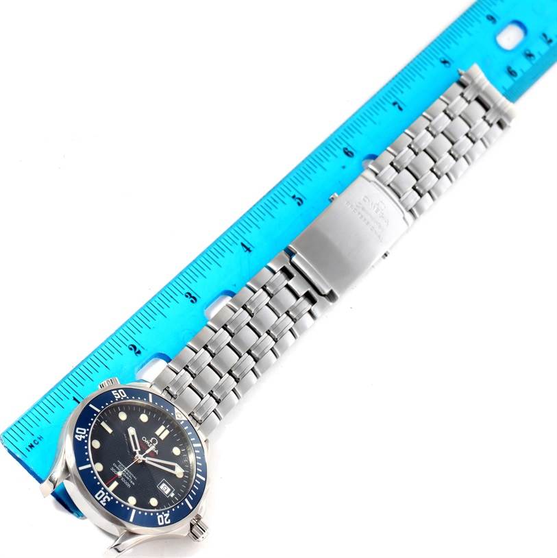 This image shows an Omega Seamaster 2220.80.00 Men
s Stainless Steel Blue Dial 2220.80.00 Men
s Stainless Steel Blue Dial watch from a top view, including its face, bezel, bracelet, and clasp next to a blue ruler.