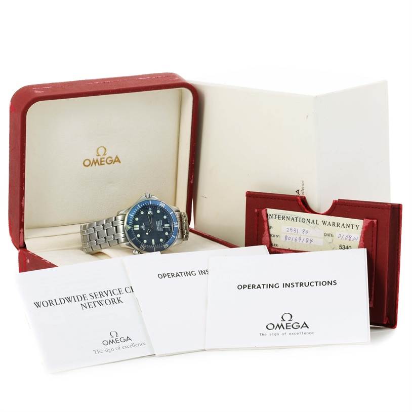 The image shows an Omega Seamaster 2531.80.00 Men
s Stainless Steel Blue Dial 2531.80.00 Men
s Stainless Steel Blue Dial watch in its open case with manuals and an international warranty card.