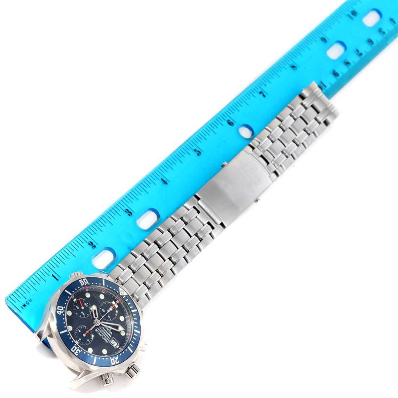 The Omega Seamaster 2599.80.00 Men
s Stainless Steel Blue Dial 2599.80.00 Men
s Stainless Steel Blue Dial watch is shown from a top-down angle, displaying the dial and stainless steel bracelet next to a blue ruler.