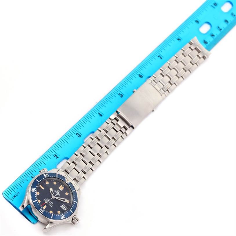 The Omega Seamaster 2561.80.00 Men
s Stainless Steel Blue Dial 2561.80.00 Men
s Stainless Steel Blue Dial watch is displayed horizontally with its bracelet, clasp, and face shown next to a blue ruler.