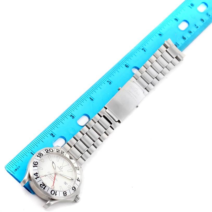 The image shows an Omega Seamaster 2538.20.00 Men's Stainless Steel White Dial 2538.20.00 Men's Stainless Steel White Dial watch and its metal bracelet laid flat beside a blue ruler.