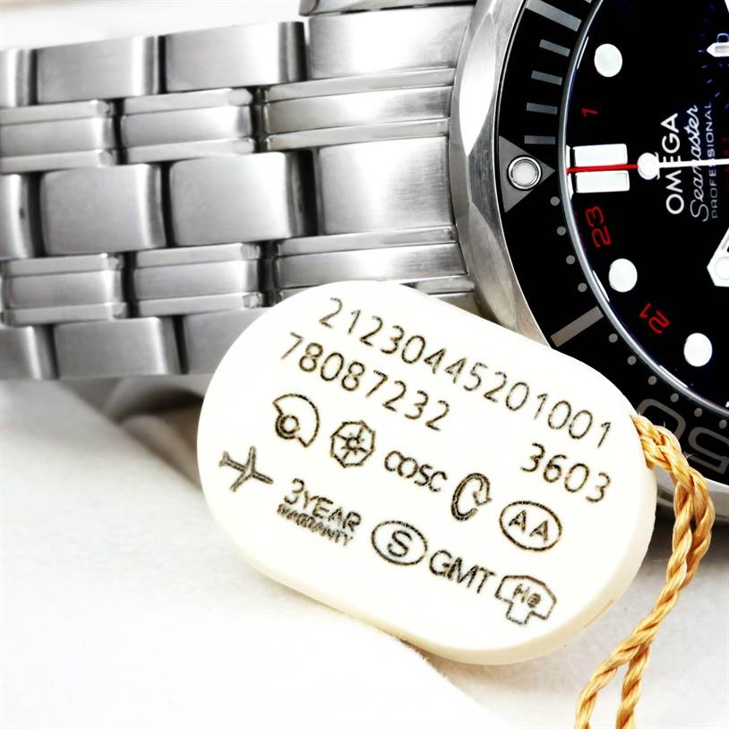 The image shows a partial view of the Omega Seamaster 212.30.44.52.01.001 Men
s Stainless Steel Black Dial 212.30.44.52.01.001 Men
s Stainless Steel Black Dial watch face, bezel, and stainless steel bracelet along with a tag displaying model information and certifications.