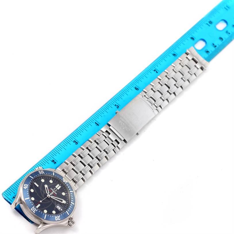 The Omega Seamaster 2226.80.00 Men
s Stainless Steel Blue Dial 2226.80.00 Men
s Stainless Steel Blue Dial watch is shown from a top-down angle, displaying its face, metal bracelet, and clasp, next to a blue ruler for scale.