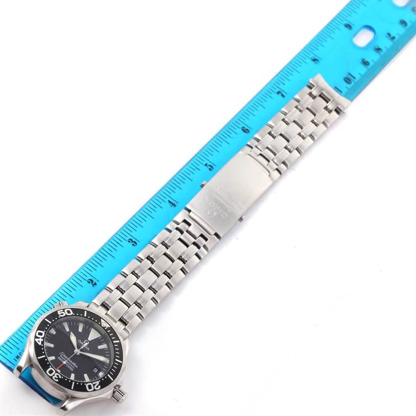 The image shows the Omega Seamaster 2262.50.00 Men
s Stainless Steel Black Dial 2262.50.00 Men
s Stainless Steel Black Dial watch laid flat next to a ruler, highlighting the watch face, bracelet, and clasp.