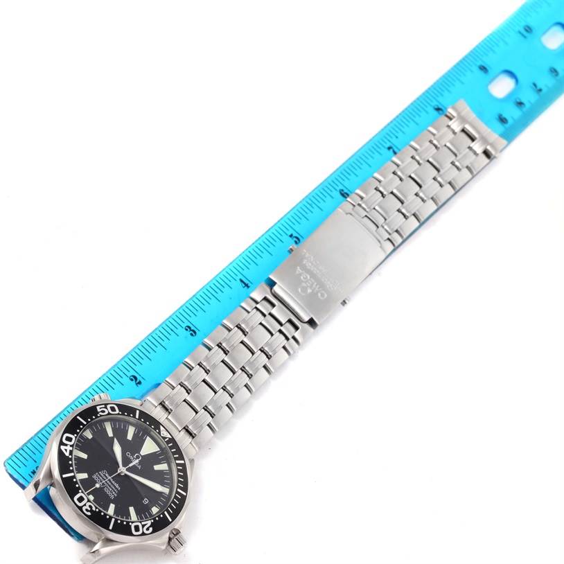 The Omega Seamaster 2254.50.00 Men
s Stainless Steel Black Dial 2254.50.00 Men
s Stainless Steel Black Dial watch is shown from an overhead angle, displaying the face, bezel, bracelet, and clasp next to a measuring ruler.