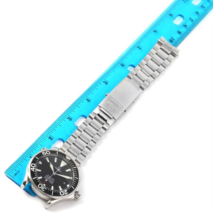 The image shows an Omega Seamaster 2254 50 00 Men
s Stainless Steel Black Dial 2254 50 00 Men
s Stainless Steel Black Dial watch laid flat next to a blue ruler, displaying its face, bezel, and metal bracelet.