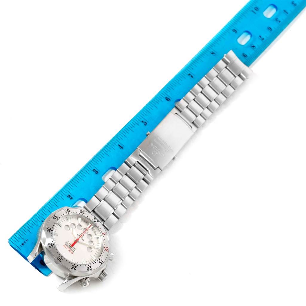 The image shows the front of an Omega Seamaster 2595.30.00 Men
s Stainless Steel Silver Dial 2595.30.00 Men
s Stainless Steel Silver Dial watch placed next to a blue ruler, displaying its metal band fully extended.