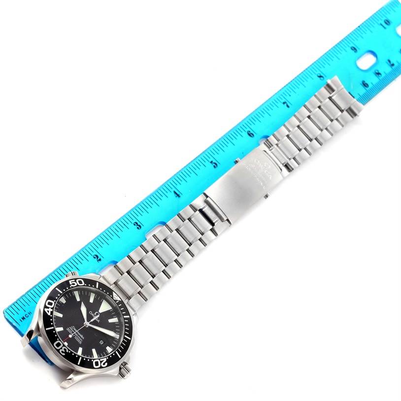 The Omega Seamaster 2264.50.00 Men
s Stainless Steel Black Dial 2264.50.00 Men
s Stainless Steel Black Dial watch is shown from a top-down angle, highlighting its face, bezel, and stainless steel bracelet next to a ruler.