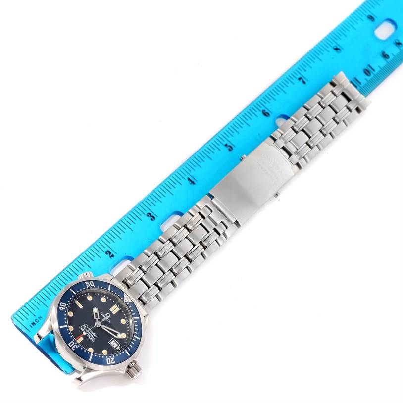 The Omega Seamaster 2561.80.00 Men
s Stainless Steel Blue Dial 2561.80.00 Men
s Stainless Steel Blue Dial watch is shown from a top-down angle, displaying the face, bezel, and bracelet with a measuring ruler alongside.