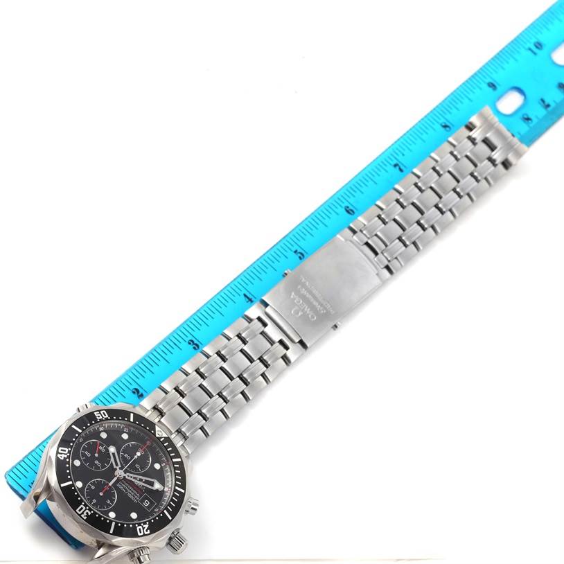 This Omega Seamaster 213.30.42.40.01.001 Men
s Stainless Steel Black Dial 213.30.42.40.01.001 Men
s Stainless Steel Black Dial watch is shown from a top-down angle, displaying its face, bezel, bracelet, and clasp alongside a ruler for scale.