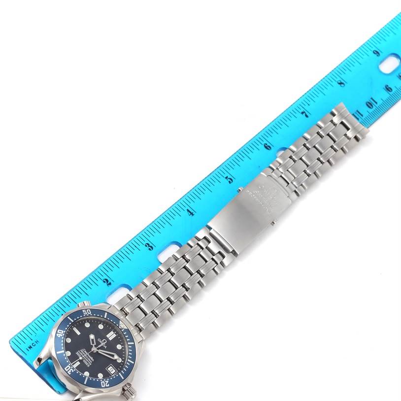 The image shows an Omega Seamaster 2551.80.00 Men's Stainless Steel Blue Dial 2551.80.00 Men's Stainless Steel Blue Dial watch laid flat with its metallic bracelet extended, next to a blue ruler for scale.