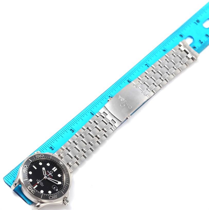 The Omega Seamaster 212.30.41.20.01.003 Men
s Stainless Steel Black Dial 212.30.41.20.01.003 Men
s Stainless Steel Black Dial watch is shown lying flat, displaying its face, bracelet, and clasp next to a blue ruler.