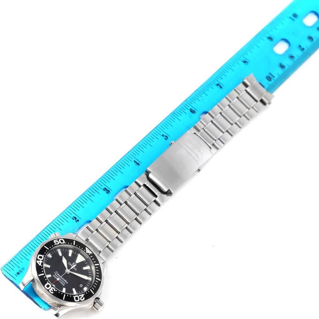 The image shows an Omega Seamaster 2262.50.00 Men's Stainless Steel Black Dial 2262.50.00 Men's Stainless Steel Black Dial watch with a stainless steel bracelet, viewed from a top-down angle, next to a blue ruler.