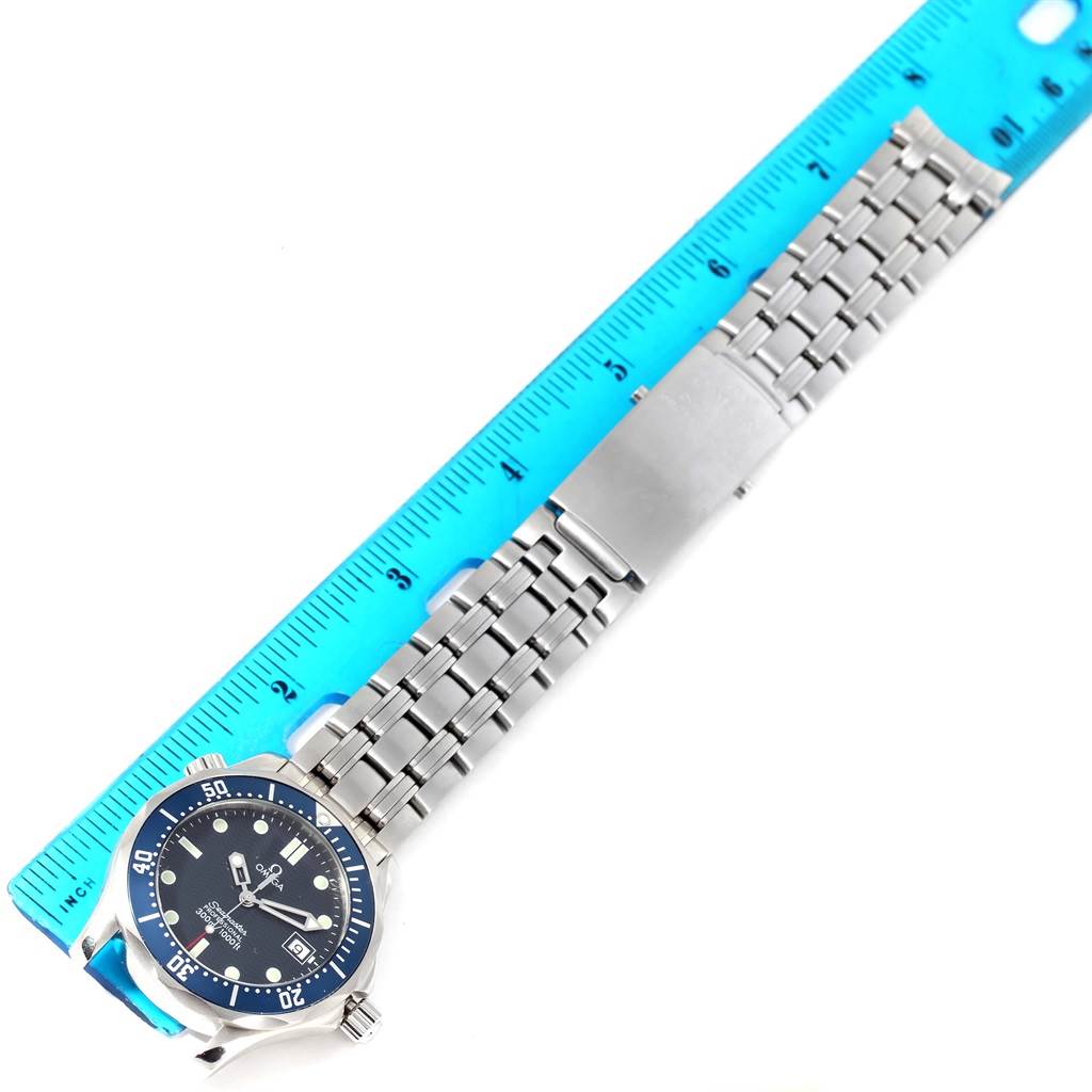 The image shows an Omega Seamaster 2561.80.00 Men
s Stainless Steel Blue Dial 2561.80.00 Men
s Stainless Steel Blue Dial watch laid flat beside a blue ruler for measurement.