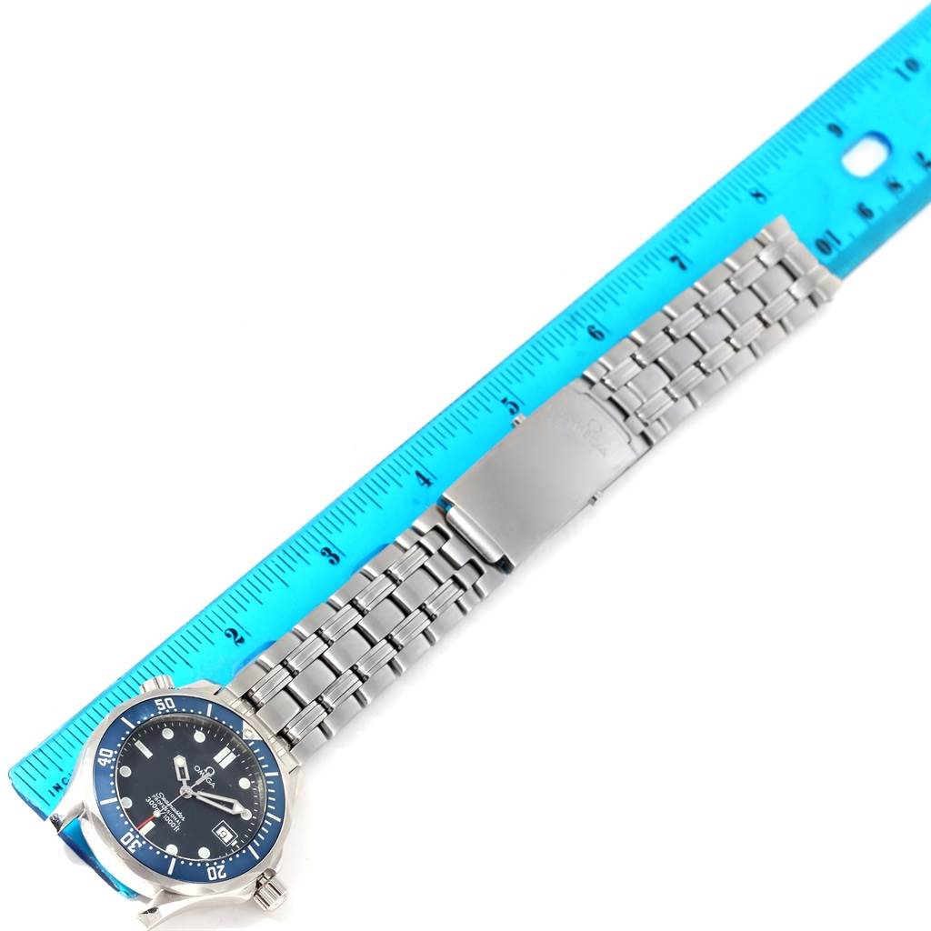 The image shows an Omega Seamaster 2561.80.00 Men
s Stainless Steel Blue Dial 2561.80.00 Men
s Stainless Steel Blue Dial watch, positioned parallel to a ruler, showcasing its dial, bezel, and stainless steel bracelet with clasp.