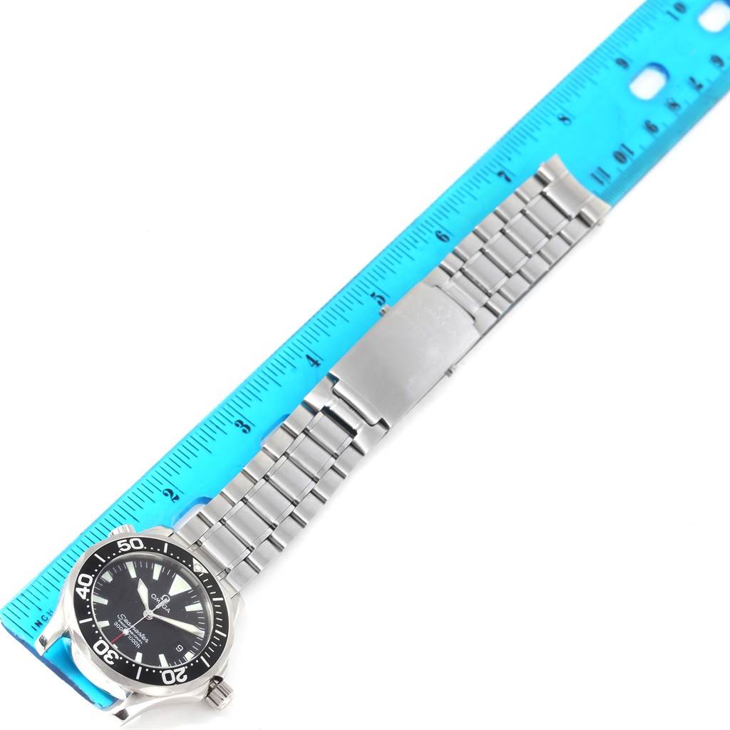 The Omega Seamaster 2262.50.00 Men
s Stainless Steel Black Dial 2262.50.00 Men
s Stainless Steel Black Dial watch is shown from a top-down angle, displaying the dial, bezel, bracelet, and clasp alongside a ruler for scale.