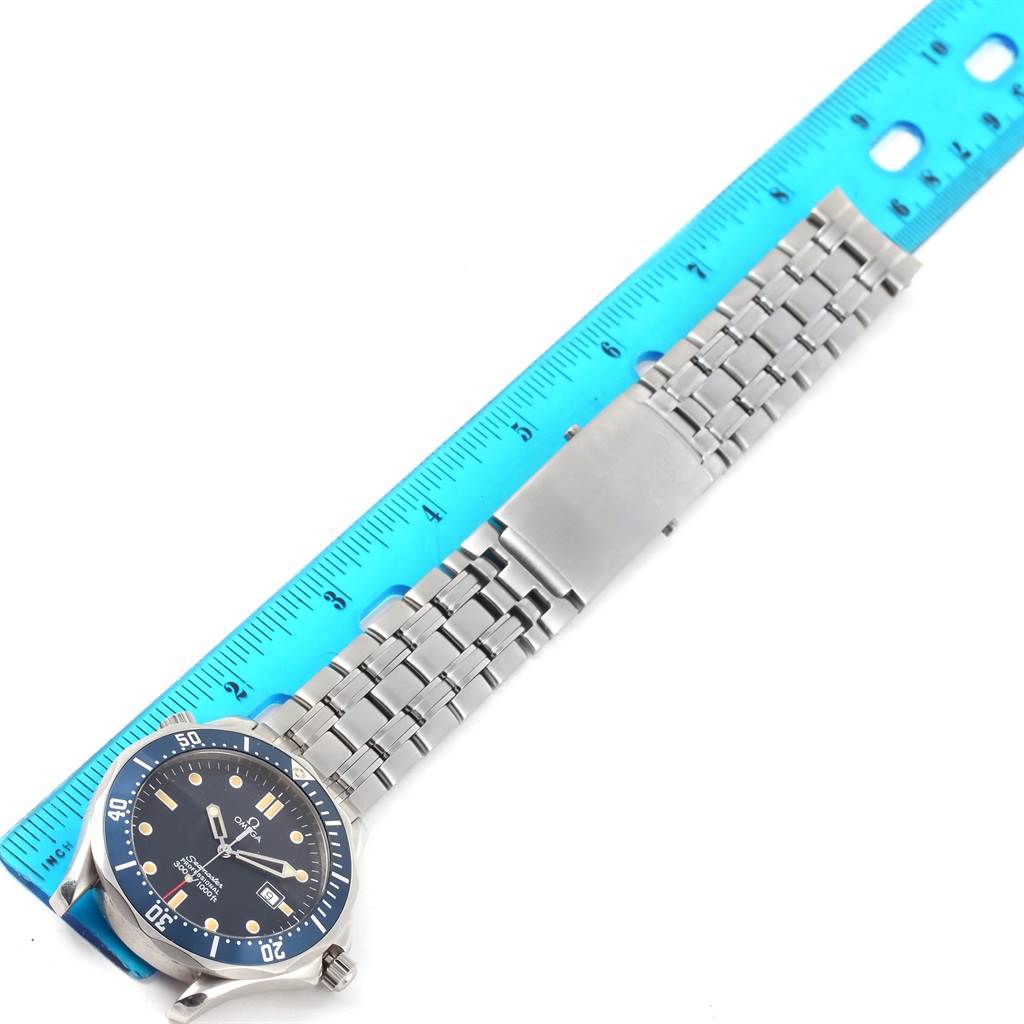 The Omega Seamaster 2541.80.00 Men
s Stainless Steel Blue Dial 2541.80.00 Men
s Stainless Steel Blue Dial watch is shown from an overhead angle, displaying the face, bezel, and metal bracelet next to a ruler for scale.