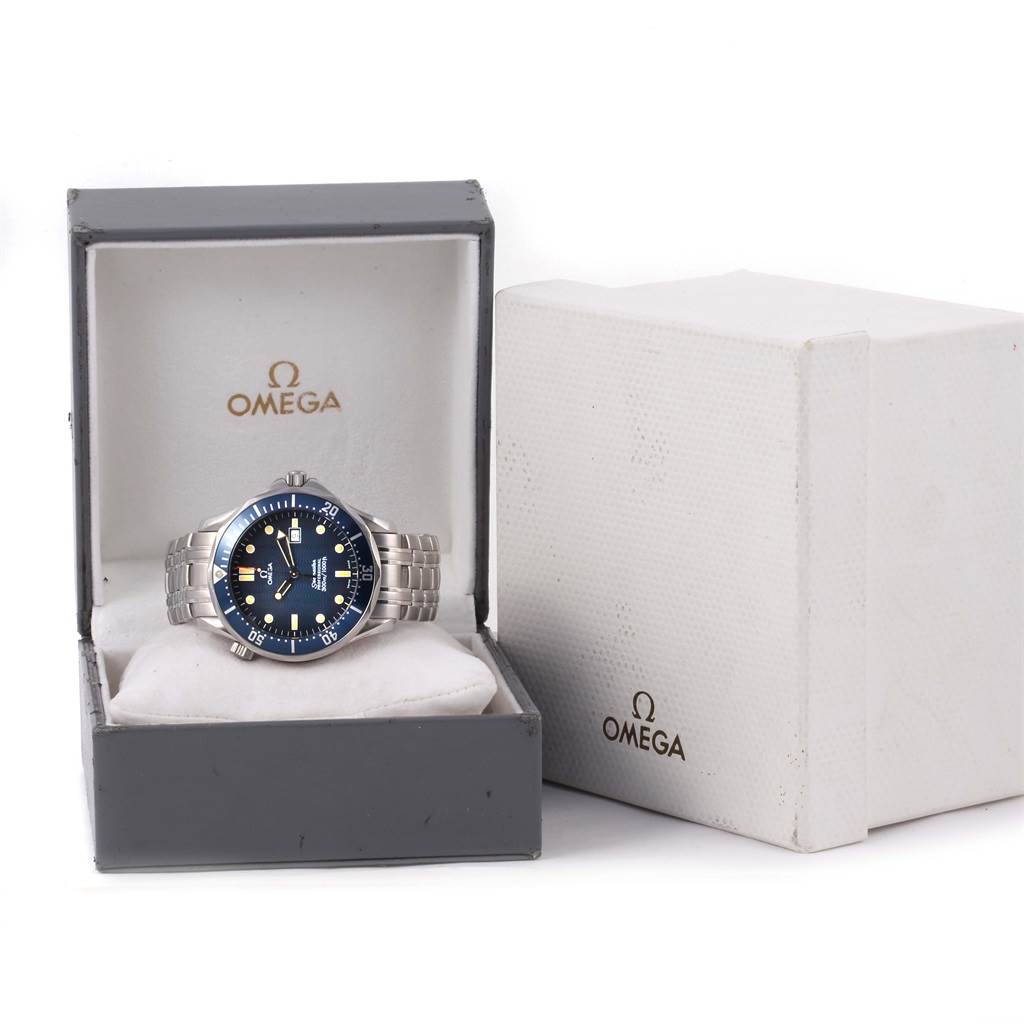 The Omega Seamaster 2541.80.00 Men
s Stainless Steel Blue Dial 2541.80.00 Men
s Stainless Steel Blue Dial watch is shown from the front, lying in an open Omega-branded box with a closed box beside it.