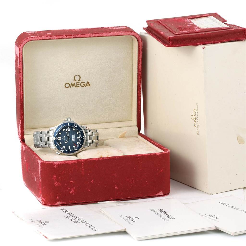 The Omega Seamaster 2561.80.00 Men
s Stainless Steel Blue Dial 2561.80.00 Men
s Stainless Steel Blue Dial watch is shown from the front, placed inside a red velvet box alongside its manuals.