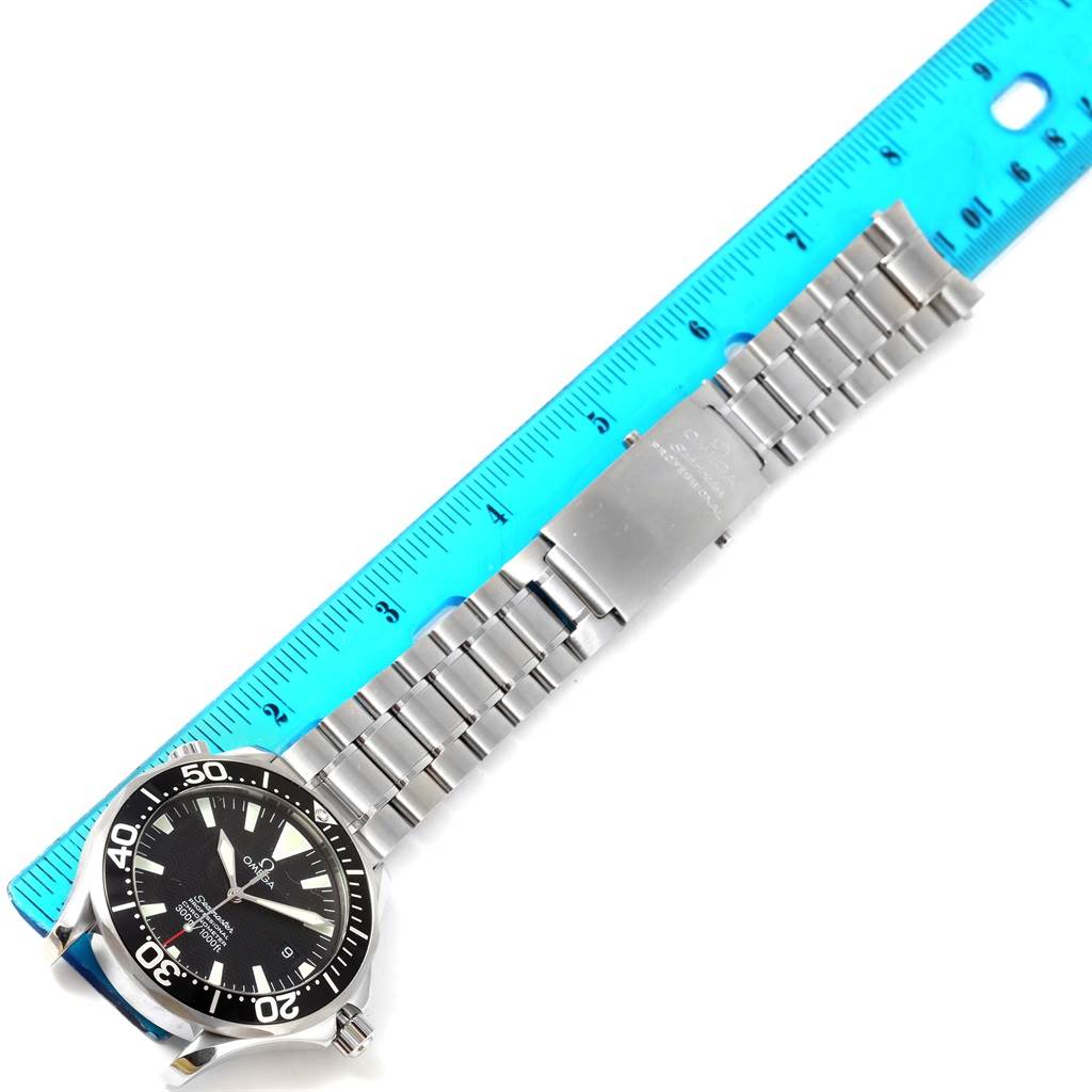 The Omega Seamaster 2254.50.00 Men
s Stainless Steel Black Dial 2254.50.00 Men
s Stainless Steel Black Dial watch is shown from a top-down angle, displaying the face, bezel, and metal bracelet with a ruler alongside for scale.