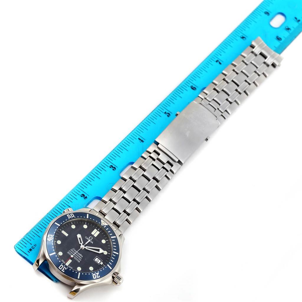 The image shows an overhead view of an Omega Seamaster 2531.80.00 Men
s Stainless Steel Blue Dial 2531.80.00 Men
s Stainless Steel Blue Dial watch with its stainless steel bracelet and a blue measurement ruler.