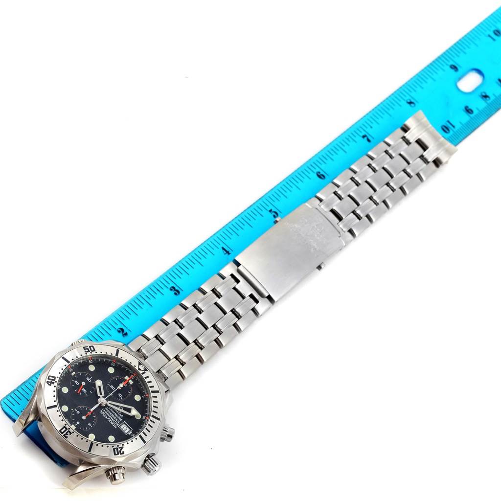 The image shows an Omega Seamaster 2598.80.00 Men's Stainless Steel Blue Dial 2598.80.00 Men's Stainless Steel Blue Dial watch laid flat on its side next to a ruler, displaying its metal bracelet and face.