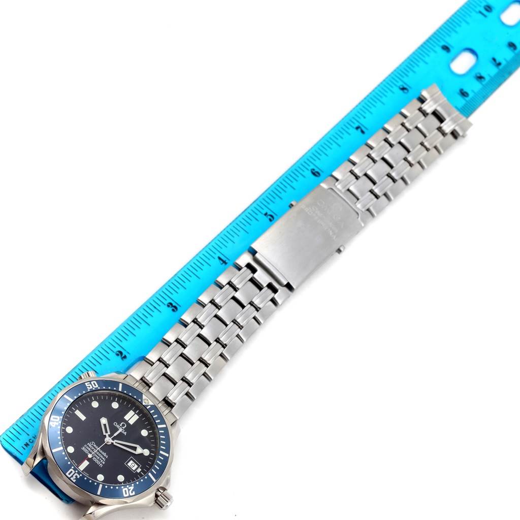 The image shows the Omega Seamaster 2531.80.00 Men
s Stainless Steel Blue Dial 2531.80.00 Men
s Stainless Steel Blue Dial watch placed next to a blue ruler, displaying the watch face and metal bracelet partially.