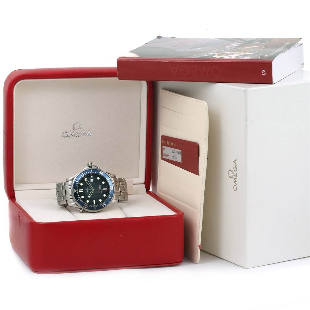 The Omega Seamaster 2221.80.00 Men
s Stainless Steel Blue Dial 2221.80.00 Men
s Stainless Steel Blue Dial watch is shown front-facing in its open box, with a warranty card and booklet beside it.