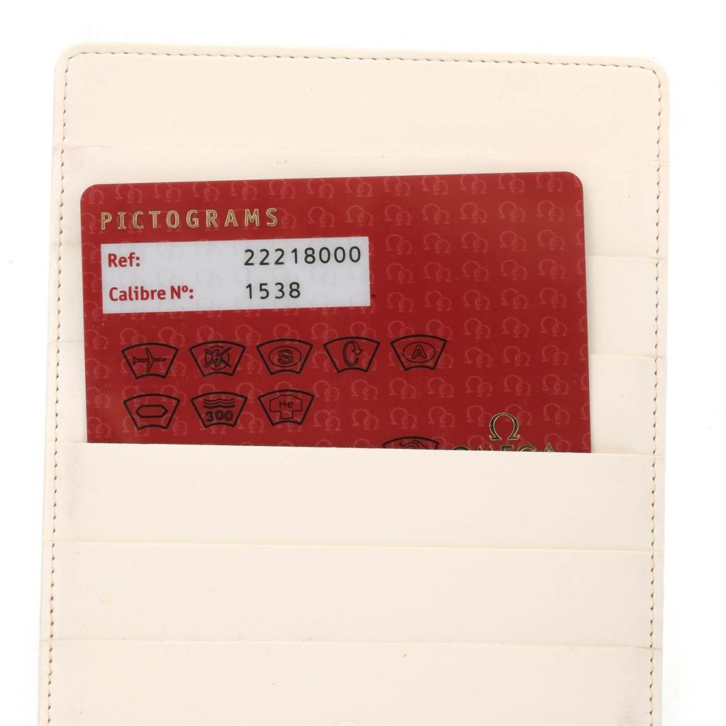 An angled photo of an Omega Seamaster 2221.80.00 Men
s Stainless Steel Blue Dial 2221.80.00 Men
s Stainless Steel Blue Dial warranty card with reference and calibre numbers in a leather cardholder.