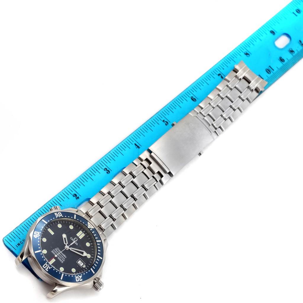 The image shows an Omega Seamaster 2531.80.00 Men
s Stainless Steel Blue Dial 2531.80.00 Men
s Stainless Steel Blue Dial watch laid flat next to a blue ruler, highlighting its metal bracelet and face.