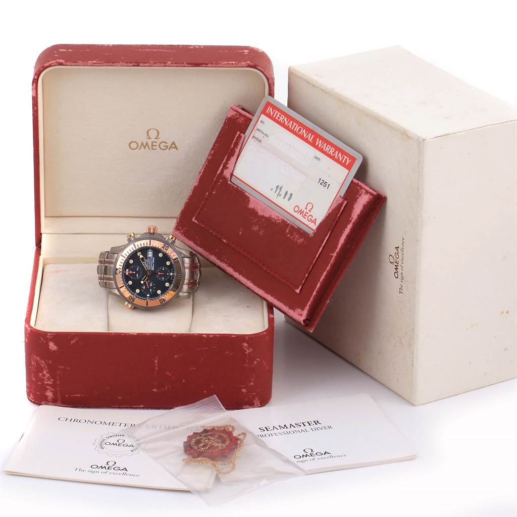 The Omega Seamaster 2296.80.00 Men's Titanium Blue Dial 2296.80.00 Men's Titanium Blue Dial watch is shown placed inside its open box along with a warranty card, manuals, and packaging.