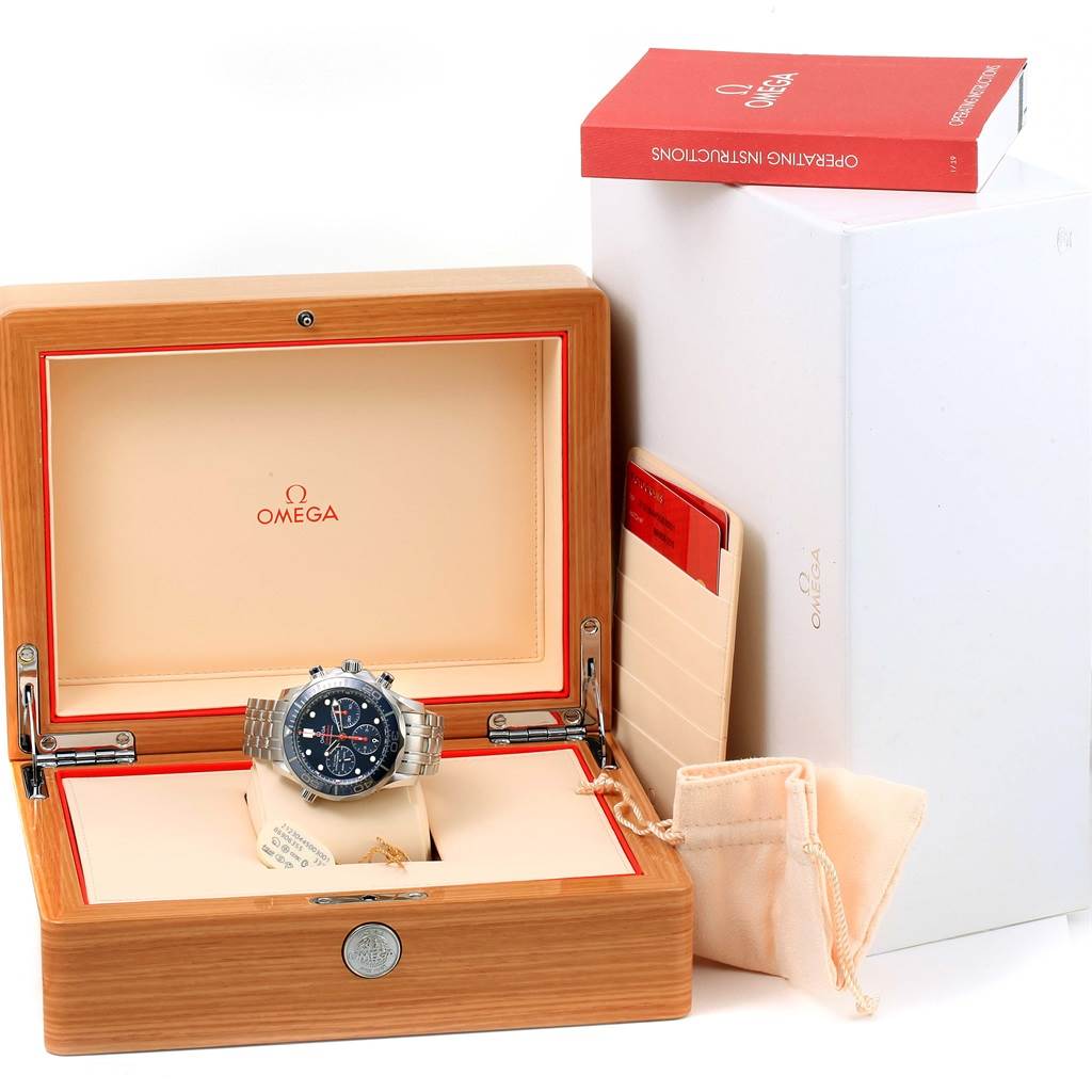 The image shows an Omega Seamaster 212.30.44.50.03.001 Men
s Stainless Steel Blue Dial 212.30.44.50.03.001 Men
s Stainless Steel Blue Dial watch placed inside an open wooden box with its accessories and instruction manual visible.