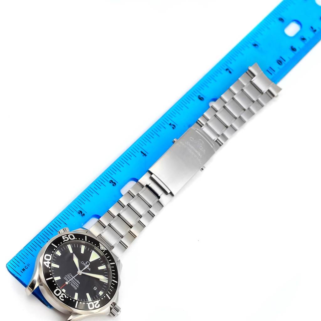 The image shows an Omega Seamaster 2254.50.00 Men
s Stainless Steel Black Dial 2254.50.00 Men
s Stainless Steel Black Dial watch laid flat with its face, bezel, bracelet, and clasp visible, next to a blue ruler.