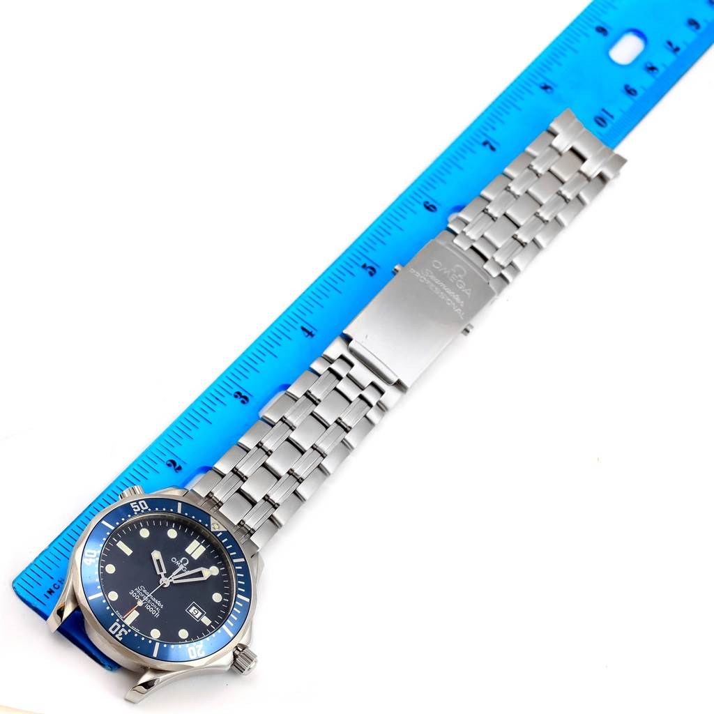 The Omega Seamaster 2541.80.00 Men
s Stainless Steel Blue Dial 2541.80.00 Men
s Stainless Steel Blue Dial watch is shown flat with a blue bezel, face, and silver link bracelet next to a blue ruler.