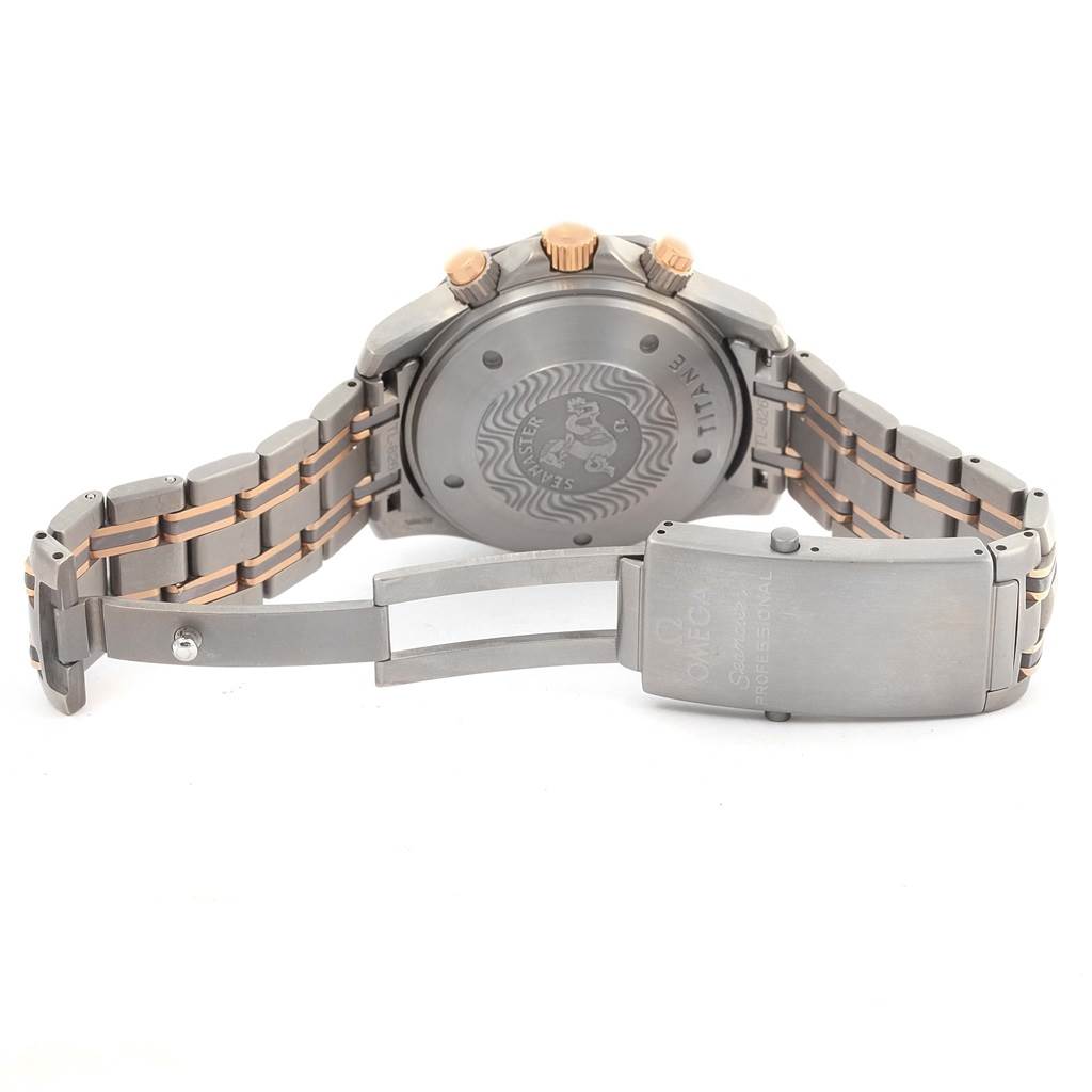 The image shows the back of an Omega Seamaster 2296.80.00 Men
s Titanium Blue Dial 2296.80.00 Men
s Titanium Blue Dial watch, including its case back, crown, and partly opened stainless steel bracelet clasp.