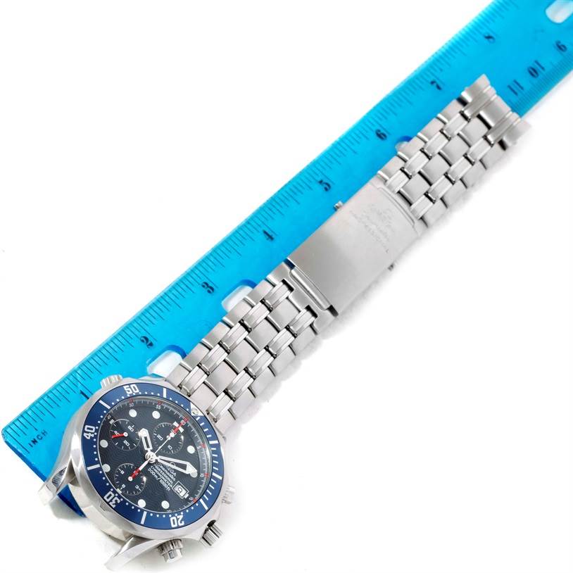 The image shows an overhead view of an Omega Seamaster 2599.80.00 Men
s Stainless Steel Blue Dial 2599.80.00 Men
s Stainless Steel Blue Dial watch, highlighting the face, bezel, and metal bracelet next to a ruler.