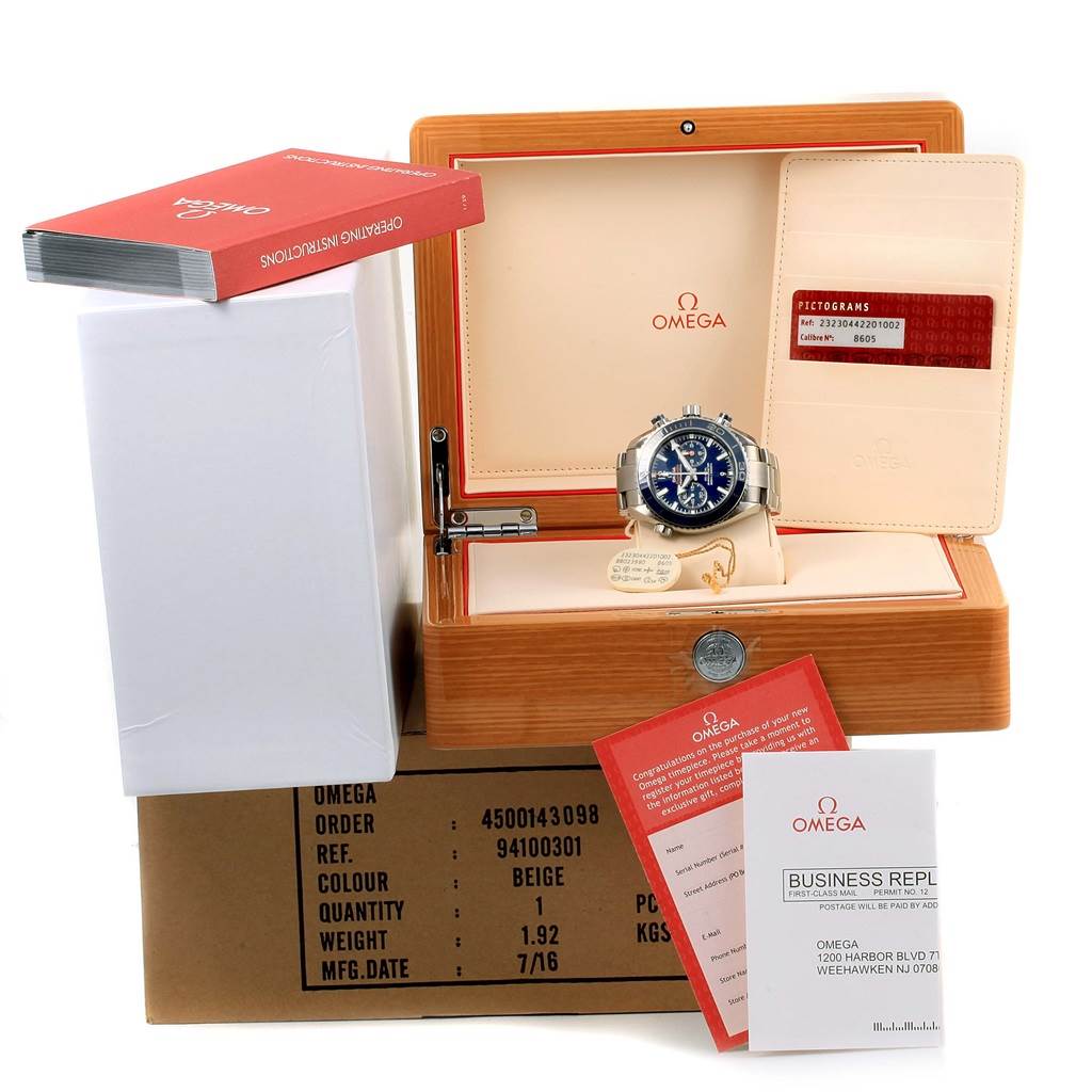 The image shows an Omega Seamaster 232.90.46.51.03.001 Men's Titanium Blue Dial 232.90.46.51.03.001 Men's Titanium Blue Dial watch in its box, along with the warranty card, instruction booklet, and other documentation.
