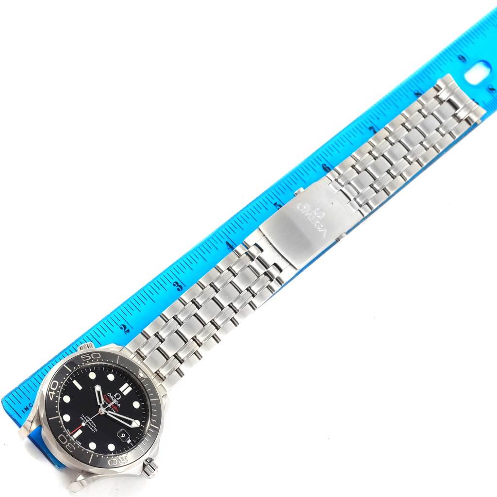 The image shows an overhead view of an Omega Seamaster 212.30.41.20.01.003 Men
s Stainless Steel Black Dial 212.30.41.20.01.003 Men
s Stainless Steel Black Dial watch with its stainless steel bracelet placed next to a ruler.