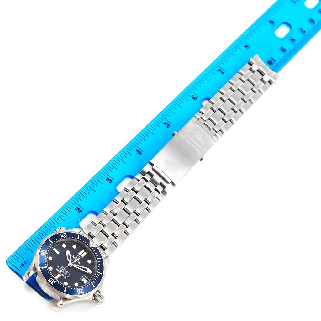 The image shows an Omega Seamaster 2222.80.00 Men
s Stainless Steel Blue Dial 2222.80.00 Men
s Stainless Steel Blue Dial watch laid flat beside a blue ruler, highlighting the bracelet and clasp.