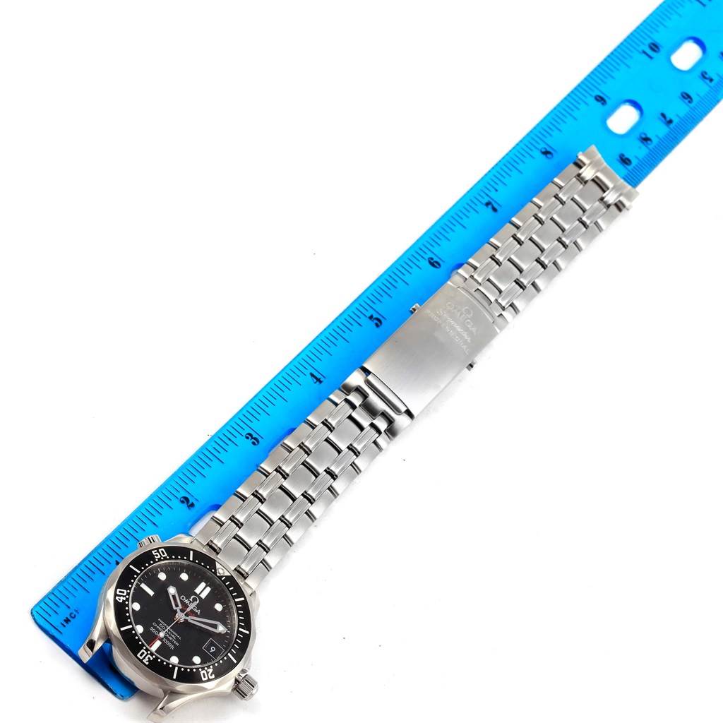 The image shows an Omega Seamaster 212.30.36.20.01.001 Men
s Stainless Steel Black Dial 212.30.36.20.01.001 Men
s Stainless Steel Black Dial watch with a stainless steel bracelet and deployment clasp, laid next to a blue ruler.