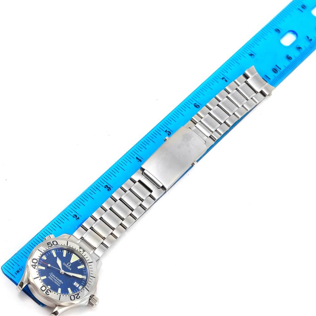 The image shows the front view of an Omega Seamaster 2263.80.00 Men
s Stainless Steel Blue Dial 2263.80.00 Men
s Stainless Steel Blue Dial watch with a blue dial and stainless steel bracelet next to a blue ruler.