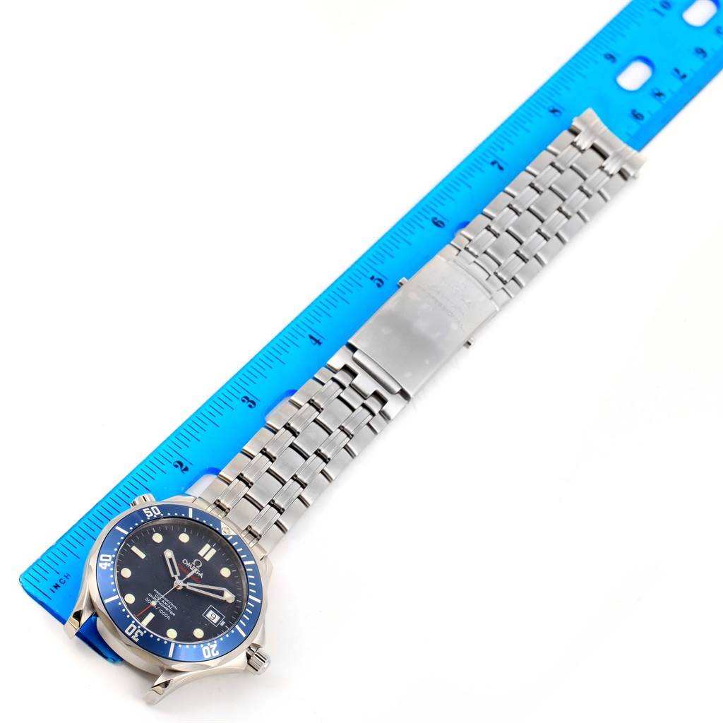 This image shows a top-down view of the Omega Seamaster 2220.80.00 Men
s Stainless Steel Blue Dial 2220.80.00 Men
s Stainless Steel Blue Dial watch, with the bracelet extended alongside a blue ruler.